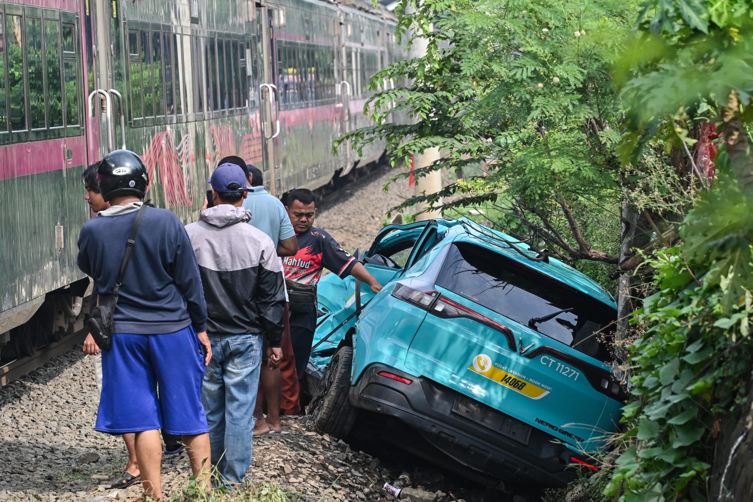 Foto. dok. Kereta api (KA) jarak jauh melintas di samping taksi listrik Green SM yang rusak pascakecelakaan KRL Commuter Line dan KA Argo Bromo Anggrek di Stasiun Bekasi Timur, Bekasi, Jawa Barat, Selasa (28/4/2026).