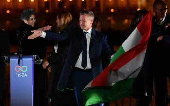 Peter Magyar, pemimpin partai konservatif pro-Eropa TISZA, mengibarkan bendera nasional di tepi sungai Danube di Hongaria, pada 12 April 2026. Foto: Ferenc Isza/AFP